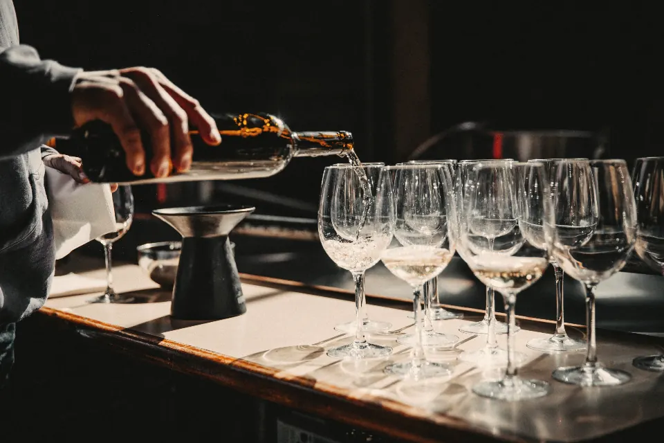 Vin versé dans une rangée de verres sur le comptoir